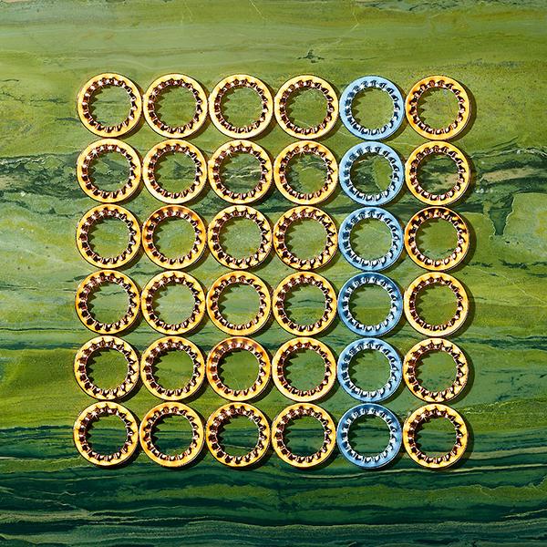 Faecherscheiben Eine Sammlung von runden, goldenen und blauen Ringen auf einem strukturierten grünen Hintergrund. Die Ringe sind in einer ordentlichen 7x7-Anordnung angeordnet, wobei die goldenen Ringe in der Mehrheit sind und die blauen Ringe in der Mitte hervorgehoben werden.